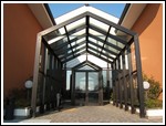 facciata strutturale serie ALU-K per copertura ingresso casa di riposo con vetro antisfondamento trasparente.