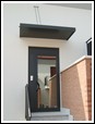 Pensilina in alluminio stampato verniciato coibentata con coppia tiranti in acciaio inox copertura ingresso condominio.
